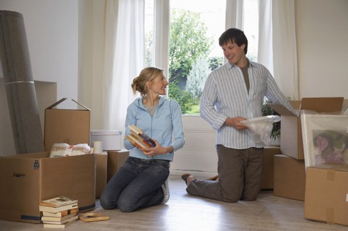 Professional movers carrying furniture through a residential property in Upton