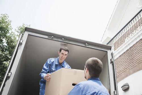 Customers preparing boxes and furniture for a removals van in Upton